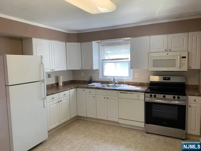 a kitchen with cabinets appliances and a window