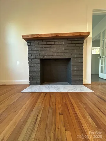 an empty room with wooden floor and fireplace