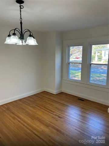 a view of empty room with wooden floor and ceiling fan