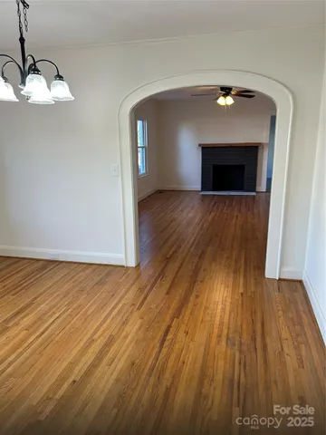 a view of empty room with wooden floor and fireplace
