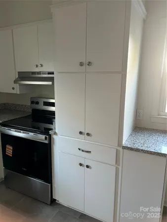 a stove top oven sitting inside of a kitchen