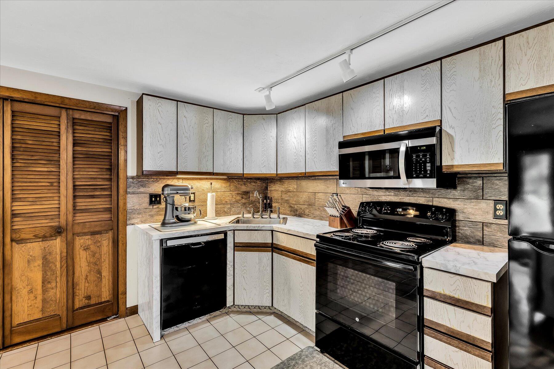 1007 River Road Marstons Mills, MA 02648 - Photo 11 of 33 a kitchen with stainless steel appliances a stove sink microwave and cabinets