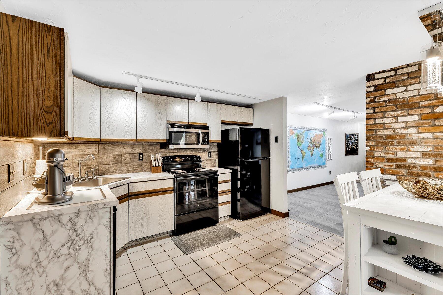 1007 River Road Marstons Mills, MA 02648 - Photo 9 of 33 a kitchen with stainless steel appliances kitchen island granite countertop a refrigerator and a stove top oven