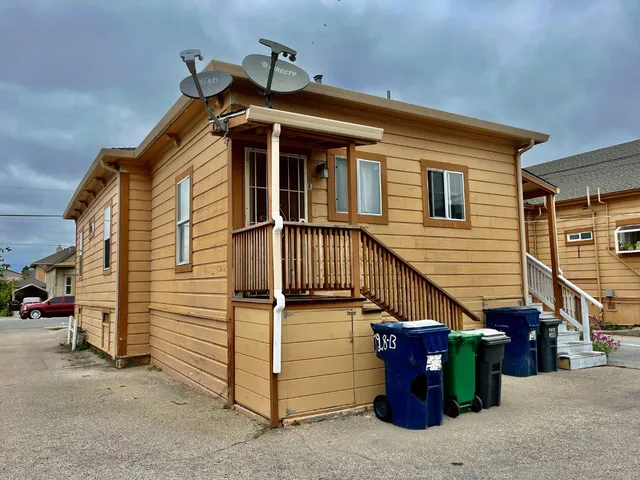 a view of a house with a small yard and wooden fence