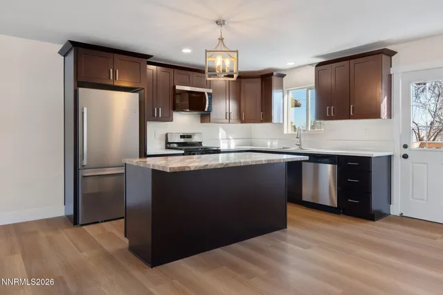 a kitchen with granite countertop a refrigerator and a sink