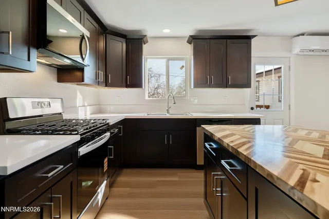a kitchen with stainless steel appliances granite countertop a sink stove and cabinets