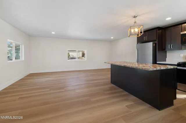 a view of a kitchen with kitchen island and stainless steel appliances