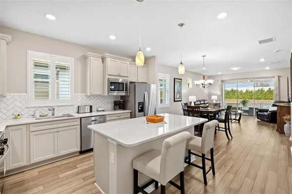 a kitchen with a table chairs stove and kitchen island