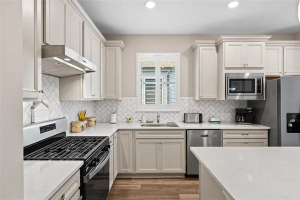a kitchen with stainless steel appliances a sink stove and cabinets