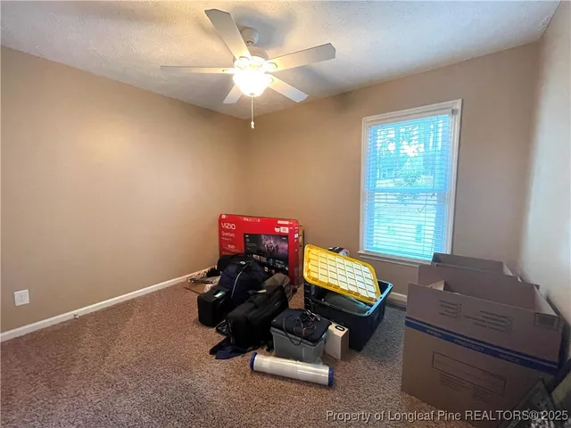 a bedroom with a bed and a ceiling fan