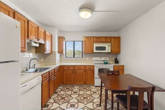 198 Locust Street, Unit 1702 Lynn, MA 01904 - Photo 8 of 26 a kitchen with a sink cabinets and dining table