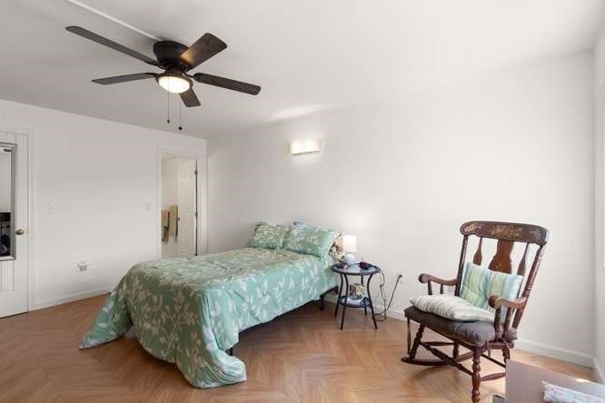 198 Locust Street, Unit 1702 Lynn, MA 01904 - Photo 10 of 26 a bedroom with a bed a chair and a potted plant