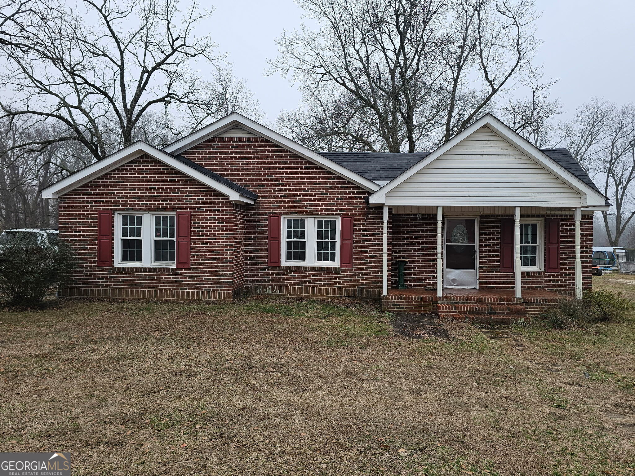 a front view of a house with yard and trees