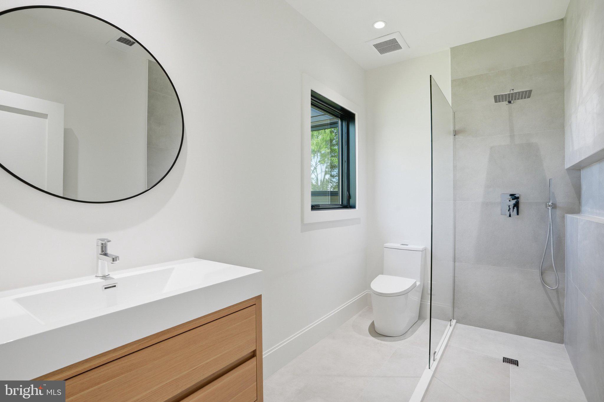 7421 Magarity Road Falls Church, VA 22043 - Photo 57 of 66 Sleek modern bathroom with natural light.