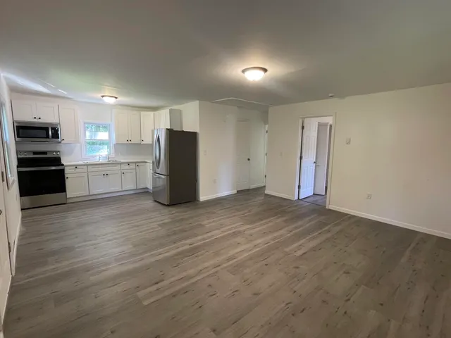 a view of a kitchen with a refrigerator a stove top oven and cabinets