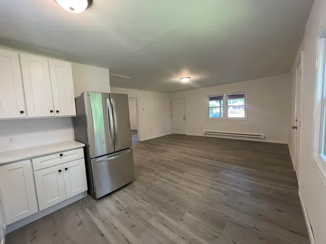 a kitchen with granite countertop a refrigerator and a stove top oven