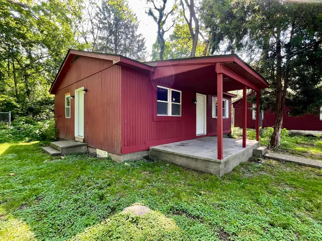 a view of a house with a yard and large trees