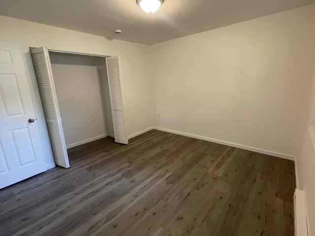 an empty room with wooden floor and closet