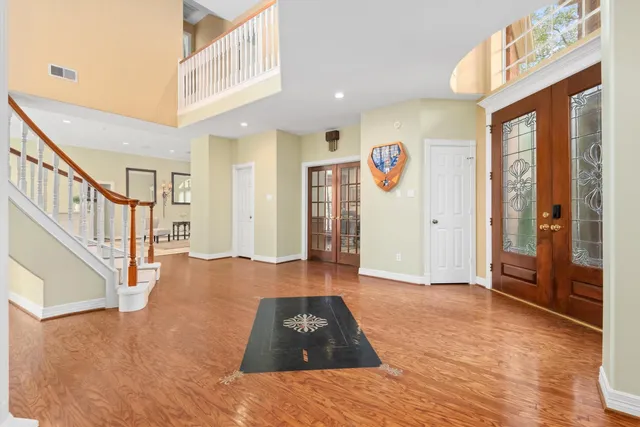 a view of a hallway with entryway wooden floor and windows