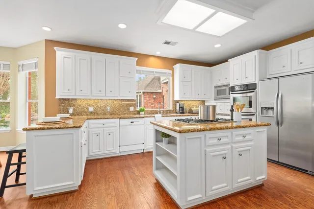 a open kitchen with stainless steel appliances granite countertop a lot of counter space and wooden floors