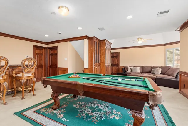 a spacious bedroom with a bed a dresser and a chandelier