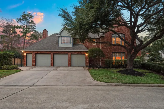 front view of house with a yard and trees all around