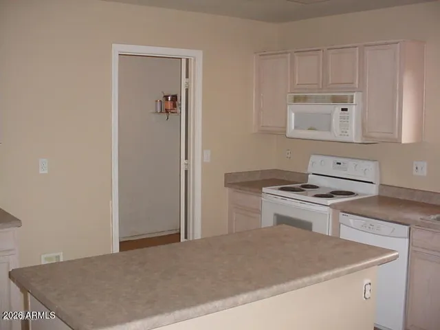 a kitchen with kitchen island granite countertop a stove sink and microwave