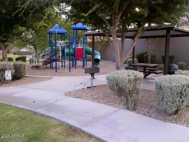 a view of a chair and table in backyard of the house
