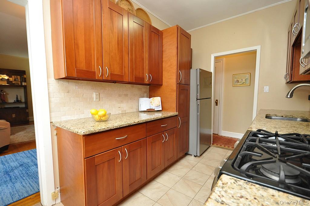 143 Garth Road, Unit 5J Scarsdale, NY 10583 - Photo 13 of 47 a kitchen with a sink stove and cabinets