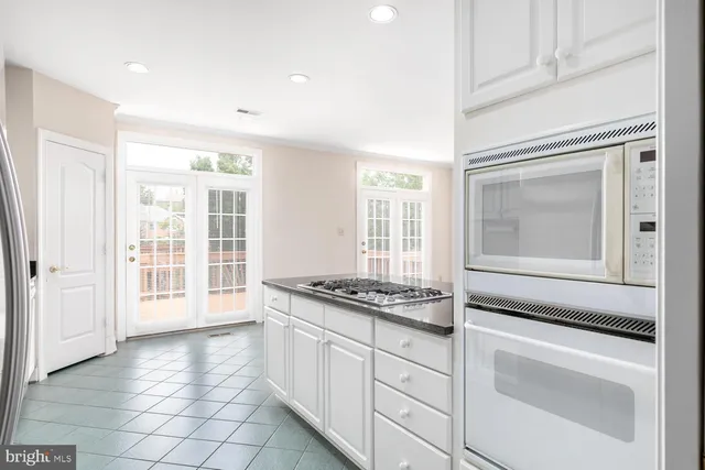 a kitchen with granite countertop white cabinets and window