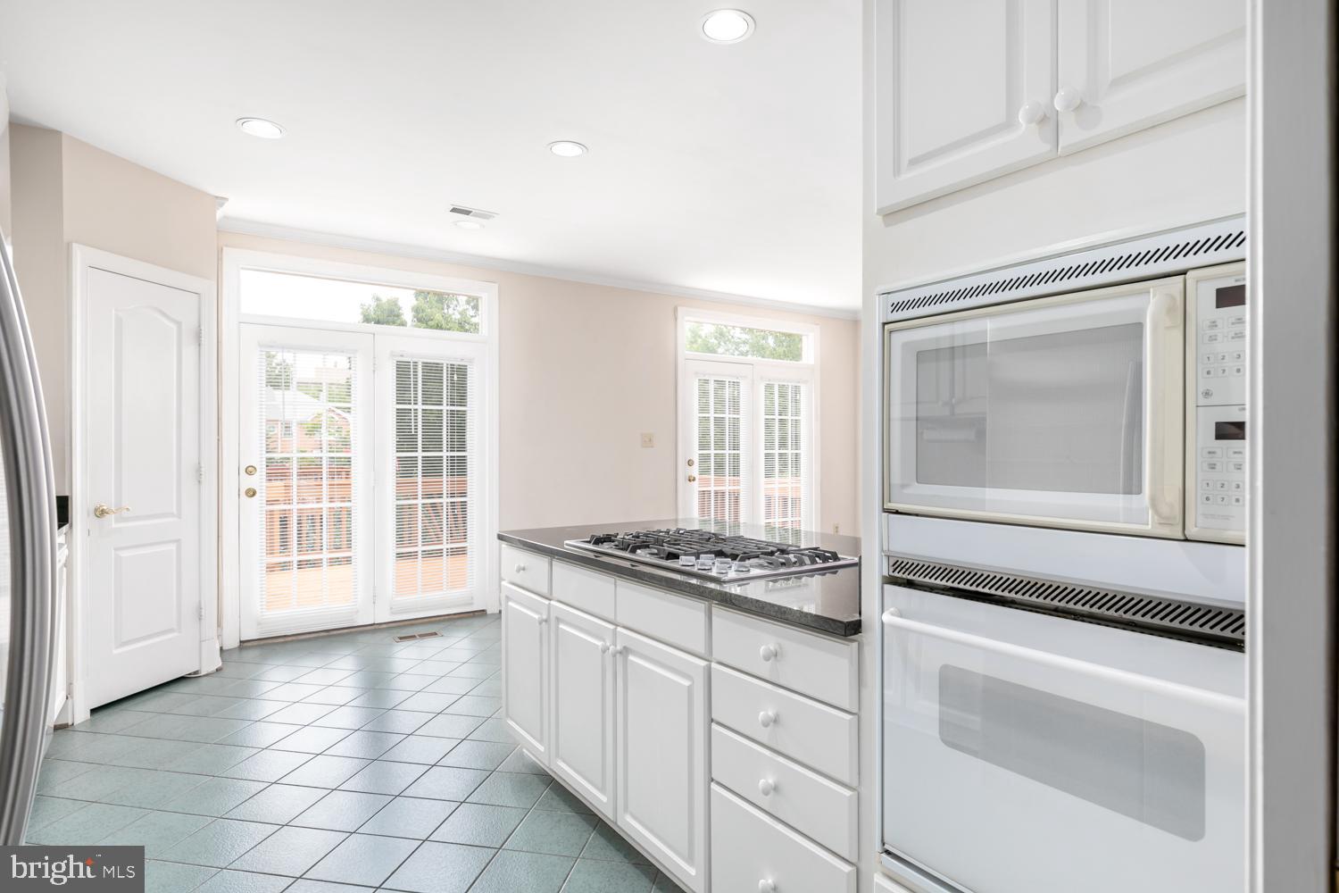 8165 Madrillon Court Vienna, VA 22182 - Photo 11 of 33 a kitchen with granite countertop white cabinets and window