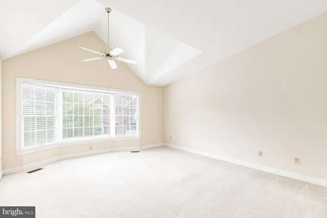 an empty room with chandelier fan
