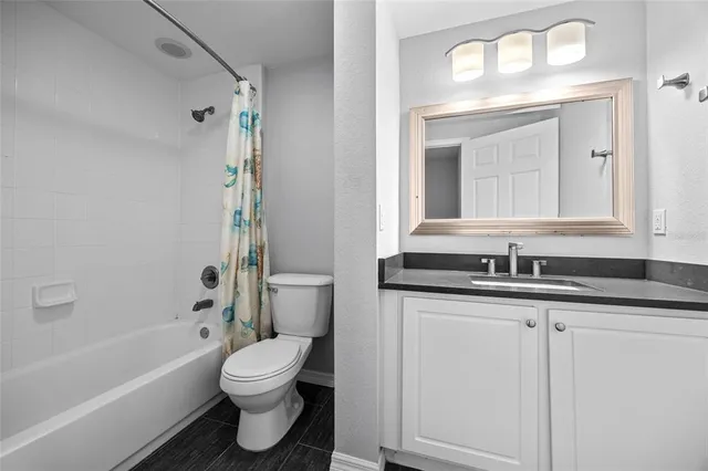 a bathroom with a granite countertop sink toilet a mirror a vanity and bathtub