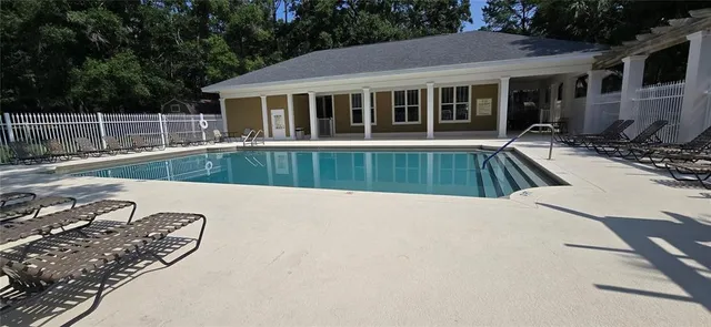 a view of a house with backyard patio and wooden fence