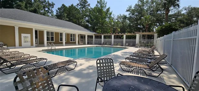 a view of a patio with table and chairs with wooden floor and fence