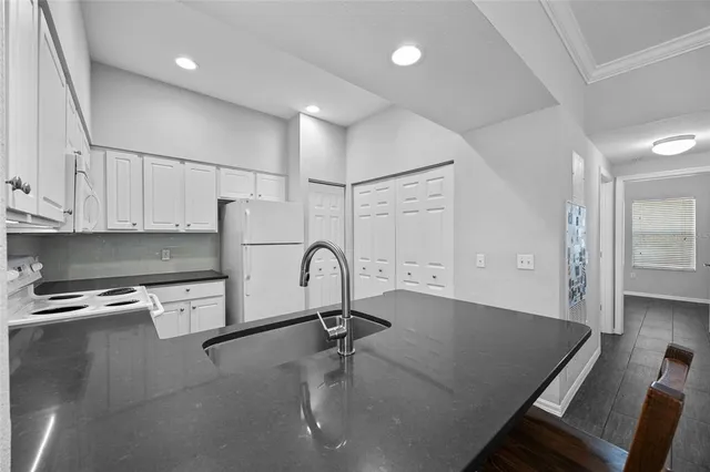 a kitchen with stainless steel appliances granite countertop a sink refrigerator and cabinets