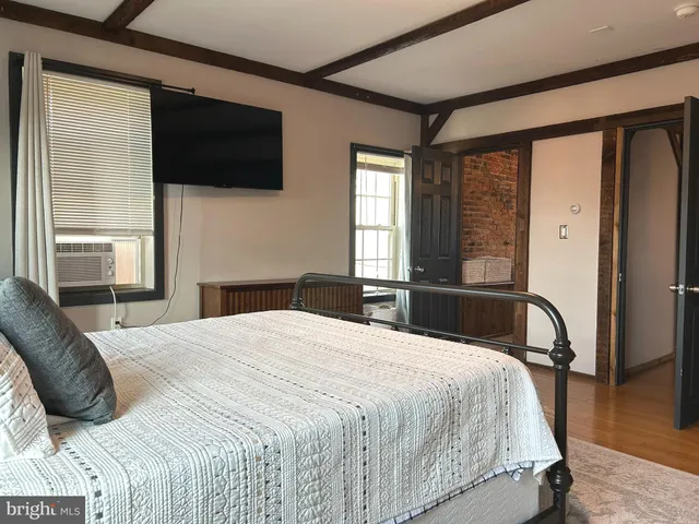 a bedroom with a bed and wooden floor