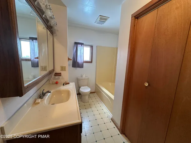 a bathroom with a sink a toilet and a mirror