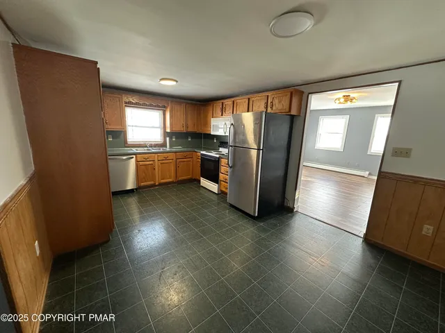 a kitchen with stainless steel appliances a refrigerator and a stove top oven