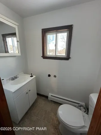 a bathroom with a toilet a sink and mirror