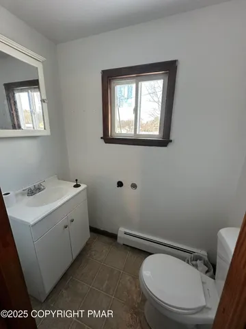 a bathroom with a toilet a sink and mirror