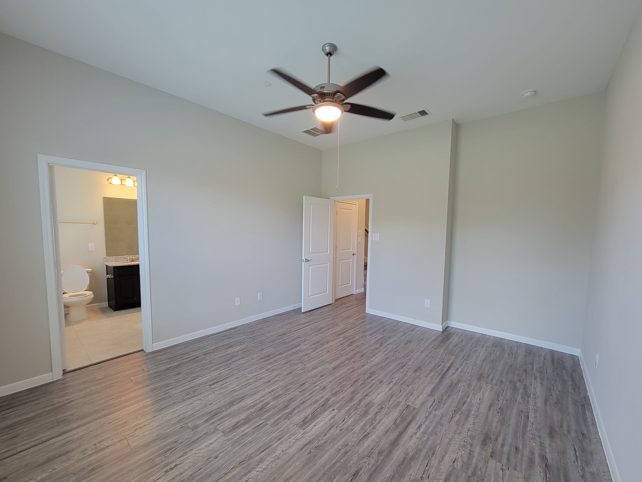 7486 Woo Street Pearland, TX 77584 - Photo 13 of 15 an empty room with wooden floor ceiling fan and window