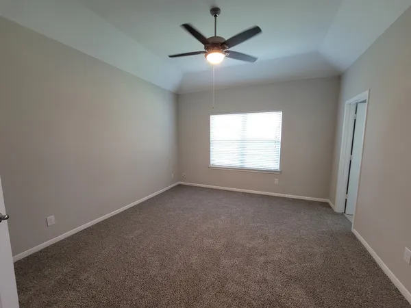 an empty room with a window and a fan