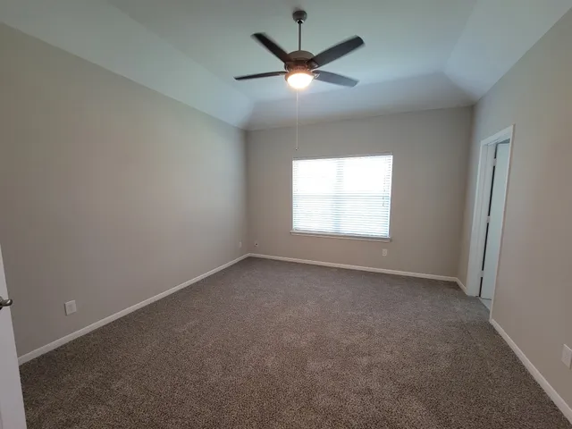 an empty room with a window and a fan
