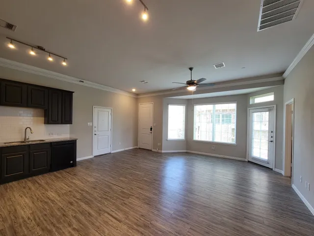 wooden floor in an empty room with a kitchen