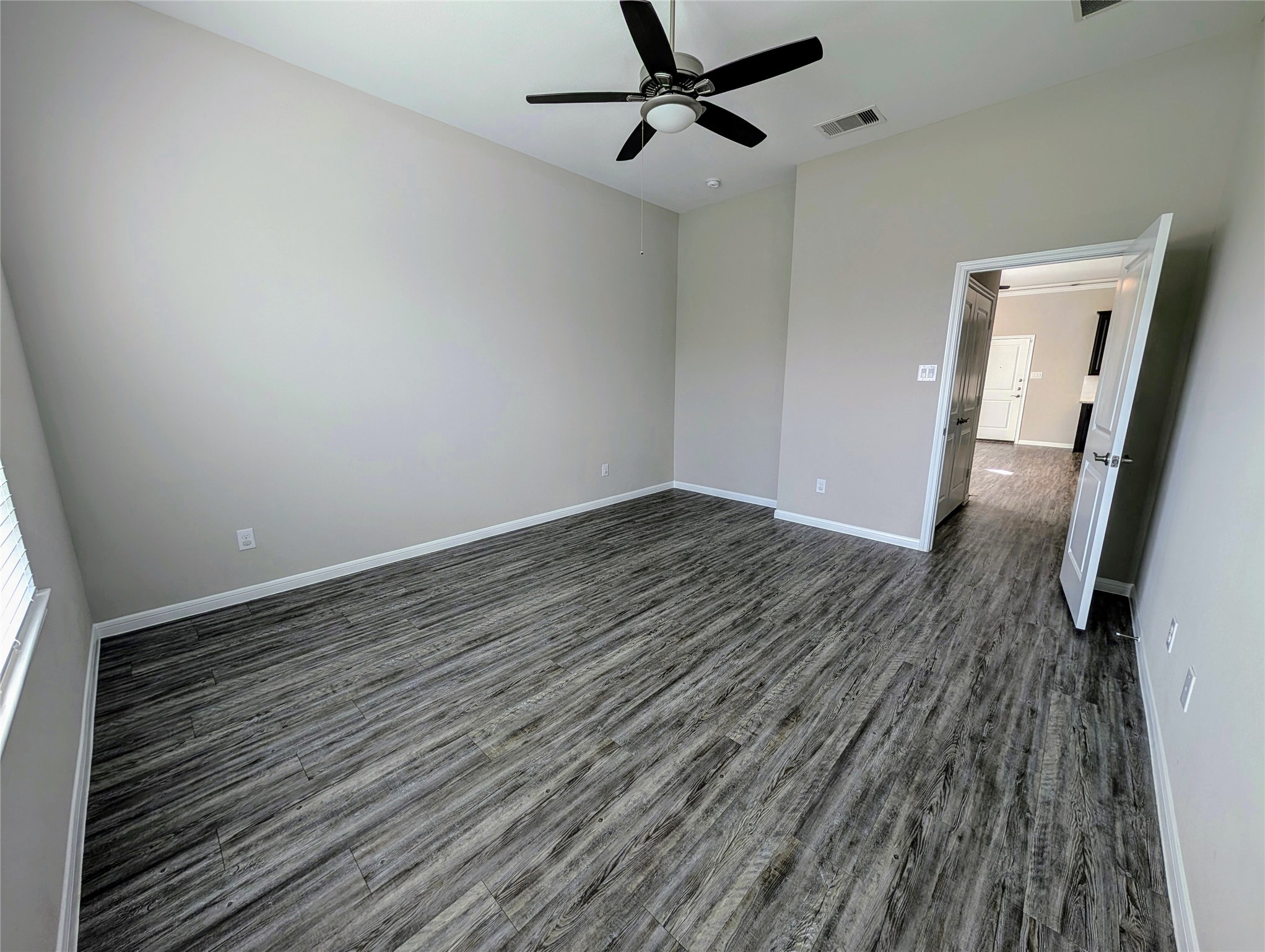 7486 Woo Street Pearland, TX 77584 - Photo 9 of 15 a view of a room with wooden floor and white walls