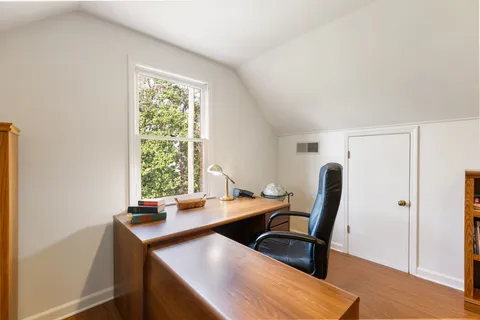 a view of a workspace with furniture and a window