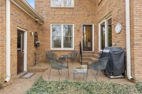 a view of a patio with couple of chairs and a potted plant