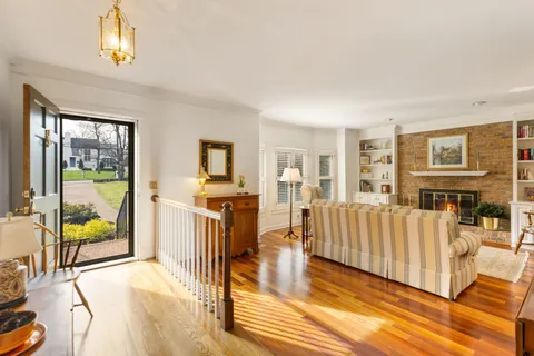 a living room with furniture a flat screen tv and a floor to ceiling window