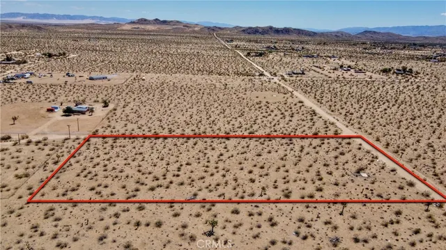 a view of a dry yard with wooden fence
